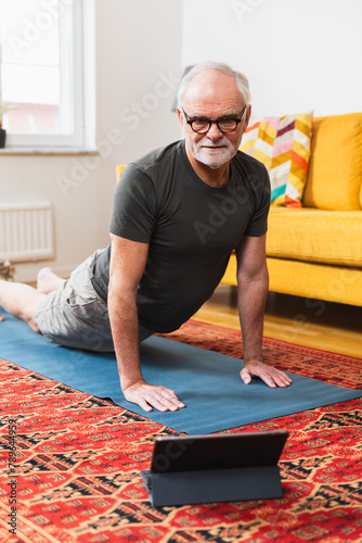 Aged man following online workout class
