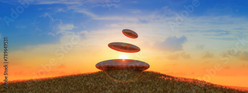 Zen Stones in Balance Against Sunset Sky on Grassy Hill