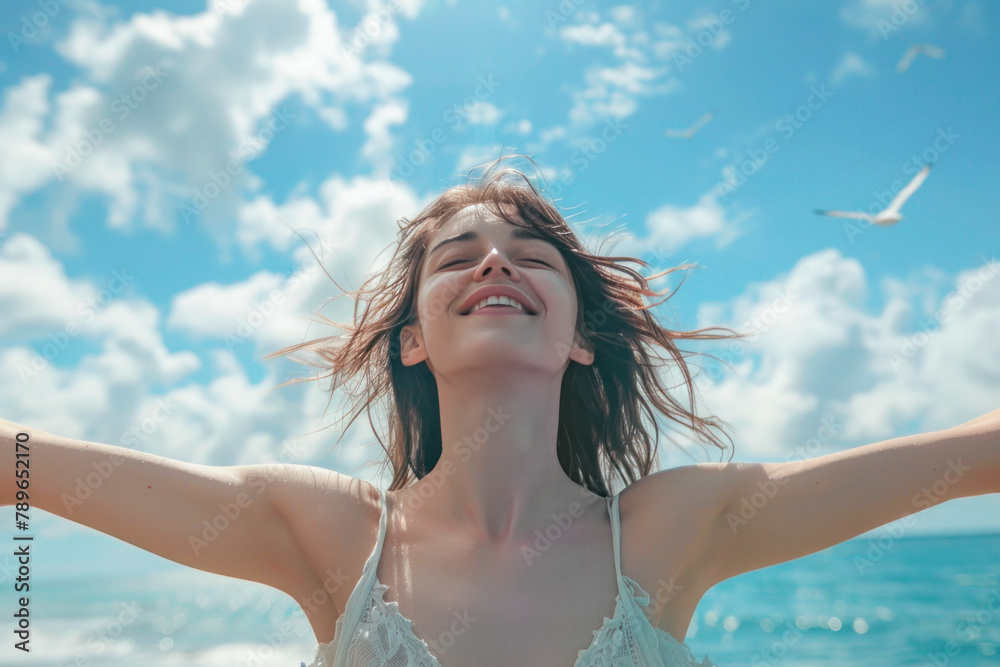 Naklejka premium Free woman with arms outstretched breathing fresh air on the beach in front of the sea dressed in street clothes. Woman breathing fresh air relaxed with her back to the sea aware of nature
