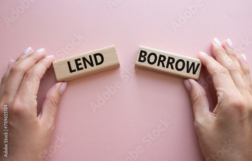 Lend or Borrow symbol. Concept word Lend or Borrow on wooden blocks. Businessman hand. Beautiful pink background. Business and Lend or Borrow concept. Copy space