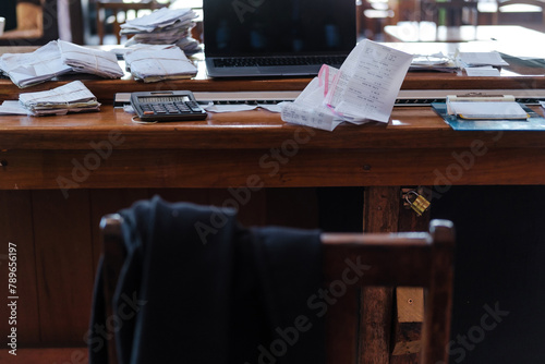 messy office with paper receipts and a  laptop
