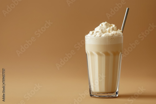 refreshing protein shake in a tall glass with a metal straw on a beige background, copy space for text photo