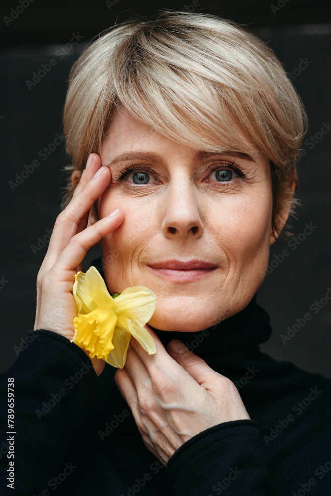 © Irina Polonina/Stocksy - Beautiful middle-aged woman with spring flower in hands. © Irina Polonina/Stocksy - Beautiful middle-aged woman with spring flower in hands.