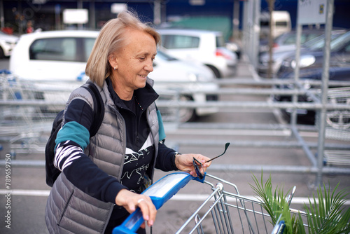 Portrait of a smiling woman pushing a shopping cart photo