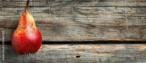 Red pear placed on a wooden background with space for text. photo