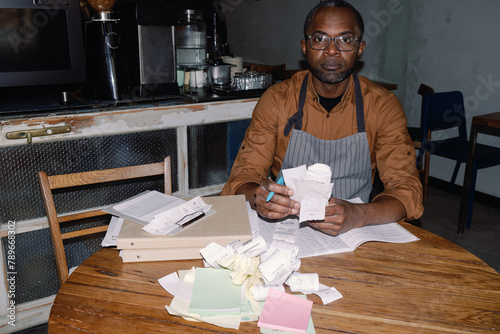 Café Owner Sorting Receipts at Business Desk
 photo