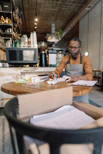 Barista immersed in finances 
