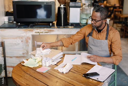 Barista sorting receipts 
 photo