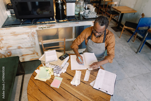 Coffee shop owner doing bookkeeping tasks
 photo