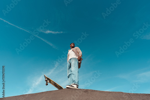 Skateboarder standing on ramp with copyspace