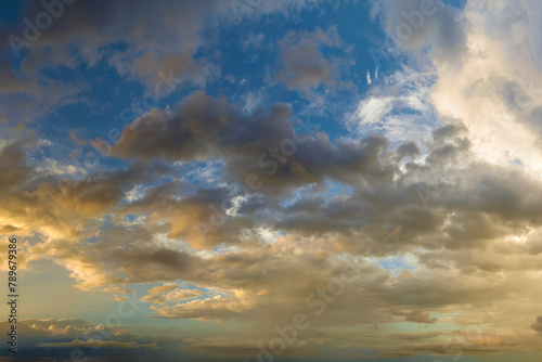 Dramatic sunset sky covered with colorful yellow clouds. Panoramic skyscape