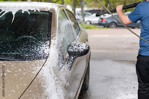 Washing the car with actin foam, spraying the car with foam under pressure. photo