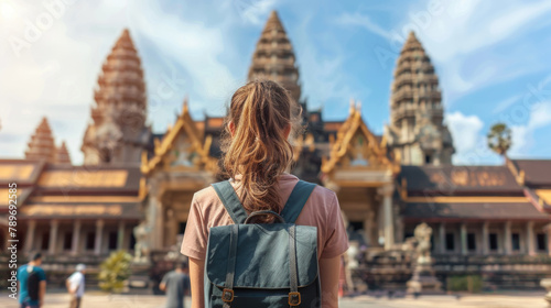 A woman standing in front of a building, wearing a backpack photo