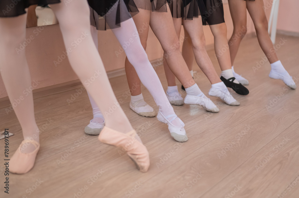 Close-up of feet of 5 little girls and teacher at ballet class. 