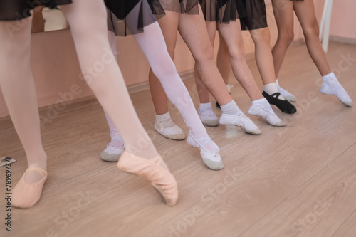 Close-up of feet of 5 little girls and teacher at ballet class. 