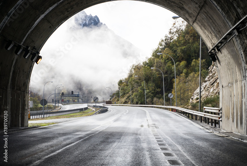Misty mountain road emerging from tunnel in Asturias photo