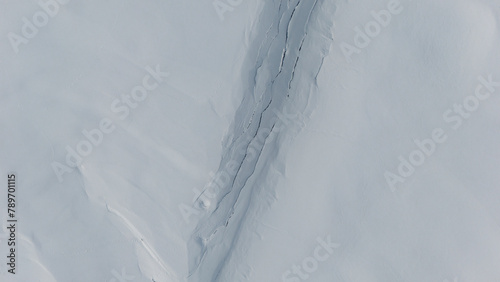 Deep Crevasse in Snowy Terrain Captured by Drone photo