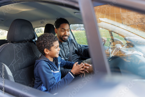 Father and son having fun while riding car photo
