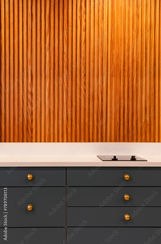Vertical Wood Paneling in Modern Home Kitchen with cooktop Vertical Wood Paneling in Modern Home Kitchen with cooktop