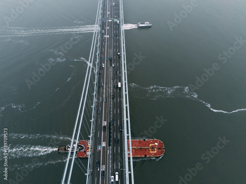 Aerial View of Vessel Passing Under Bridge