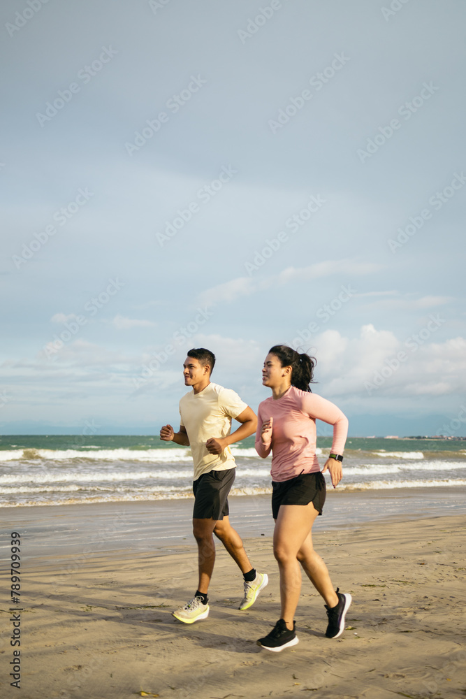Friends running on the beach in the morning Friends running on the beach in the morning