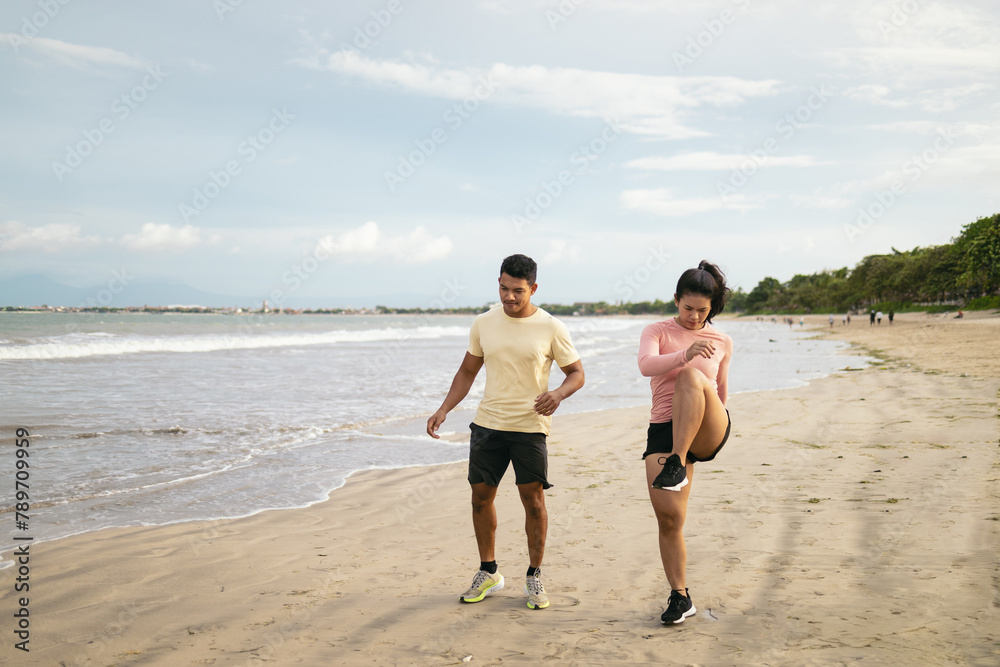 Asian friends on the beach in sportswear Asian friends on the beach in sportswear