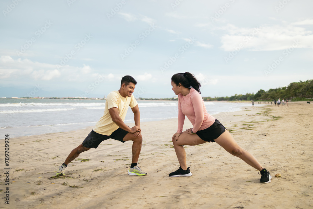 Couple warming out for running on the beach Couple warming out for running on the beach