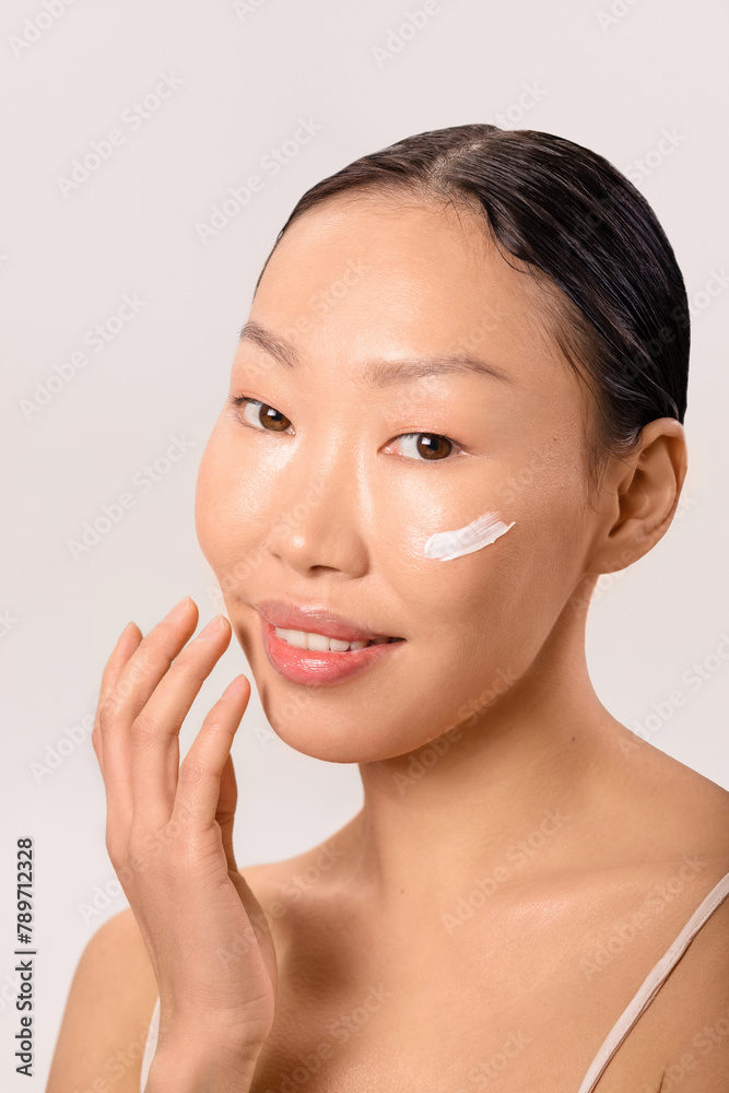 Beautiful young woman with moisturizing cream on her face Beautiful young woman with moisturizing cream on her face