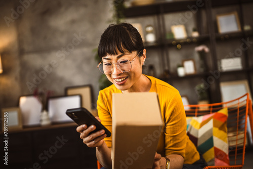 japanese woman checking box of received package or product at home