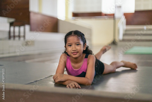 Portrait of a young gymnast girl lying down photo
