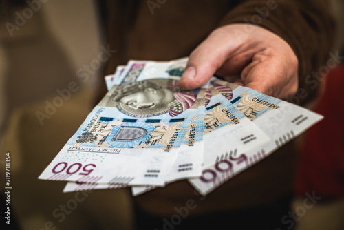 Close up on a mans hand holding polish zloty banknotes economic situation income in poland