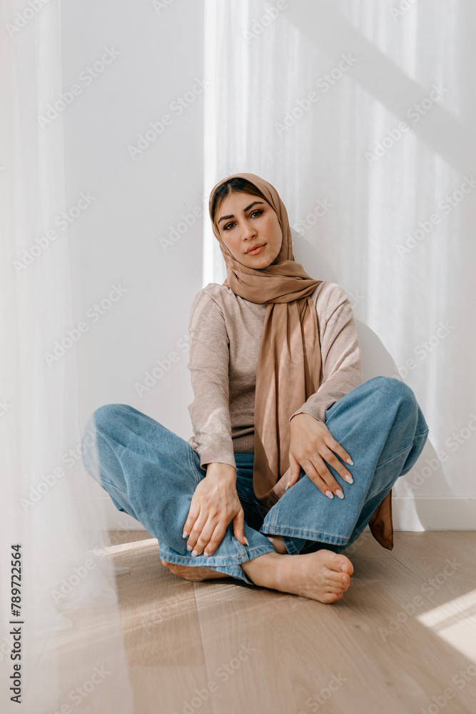 Young smiling woman sitting on floor in studio Young smiling woman sitting on floor in studio