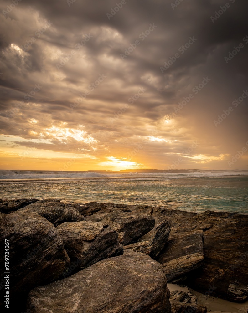 Dramatic sunset seascape with approaching thunderstorm clouds.