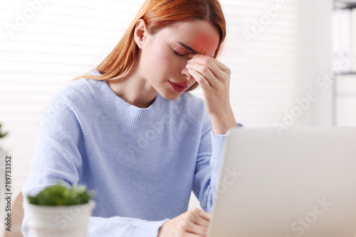 Young woman suffering from headache at home