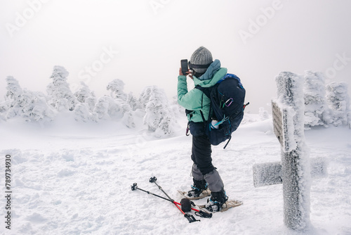 Hiker taking photo on peak of Mount Jackson, White Mountains NH photo