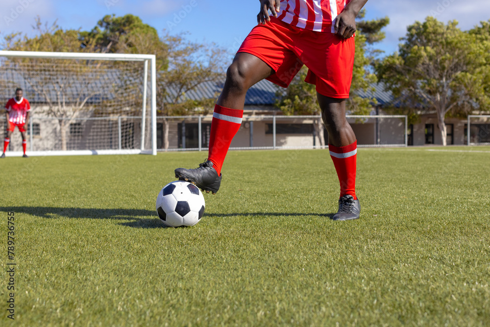 Two African American young male athletes are playing soccer on field outdoors Two African American young male athletes are playing soccer on field outdoors