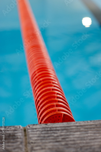 Red lane dividers stretching across a blue swimming pool indoors