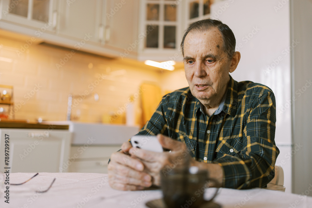 Senior man using modern smartphone at home for video call Senior man using modern smartphone at home for video call