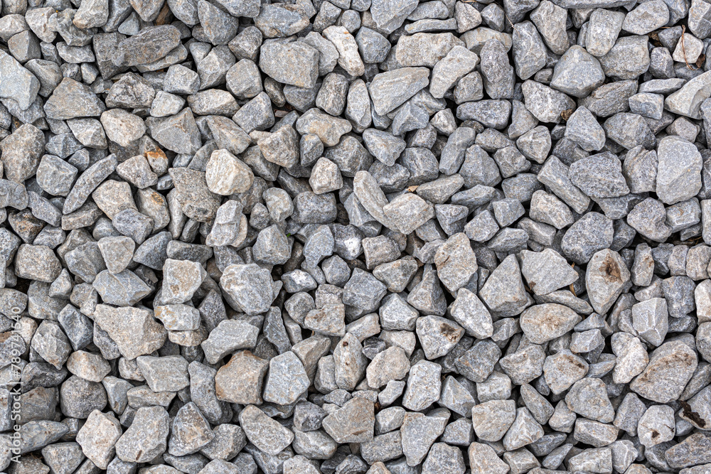 A detailed texture of gray gravel evenly sprinkled with brown iron oxide spots fills the entire frame, offering a natural, earthy pattern. A detailed texture of gray gravel evenly sprinkled with brown iron oxide spots fills the entire frame, offering a natural, earthy pattern.