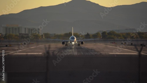 Airplane is speeding up and taking off from Harry Reid International Airport in Las Vegas at evening during sunset in beautiful place in Nevada