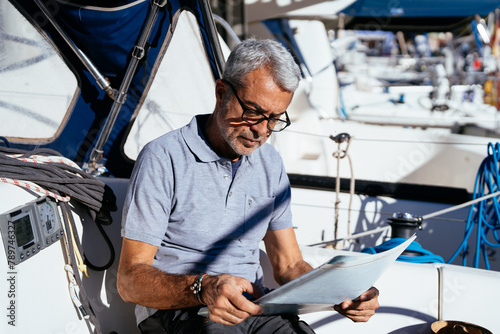 senior man in his boat reading photo