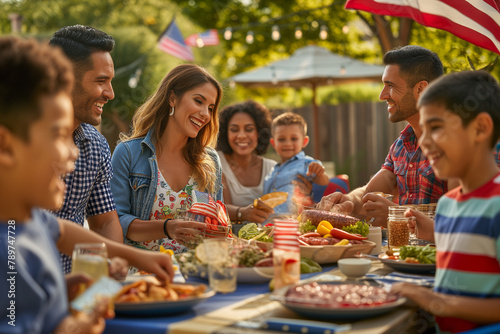 Hispanic family and friends enjoy a backyard summer barbecue grill cookout dinner party on 4th of July photo