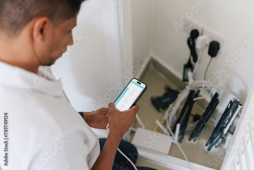Focused man using smartphone during technical work photo