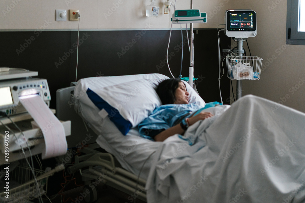 Pregnant woman sleeping on medical bed in hospital room Pregnant woman sleeping on medical bed in hospital room