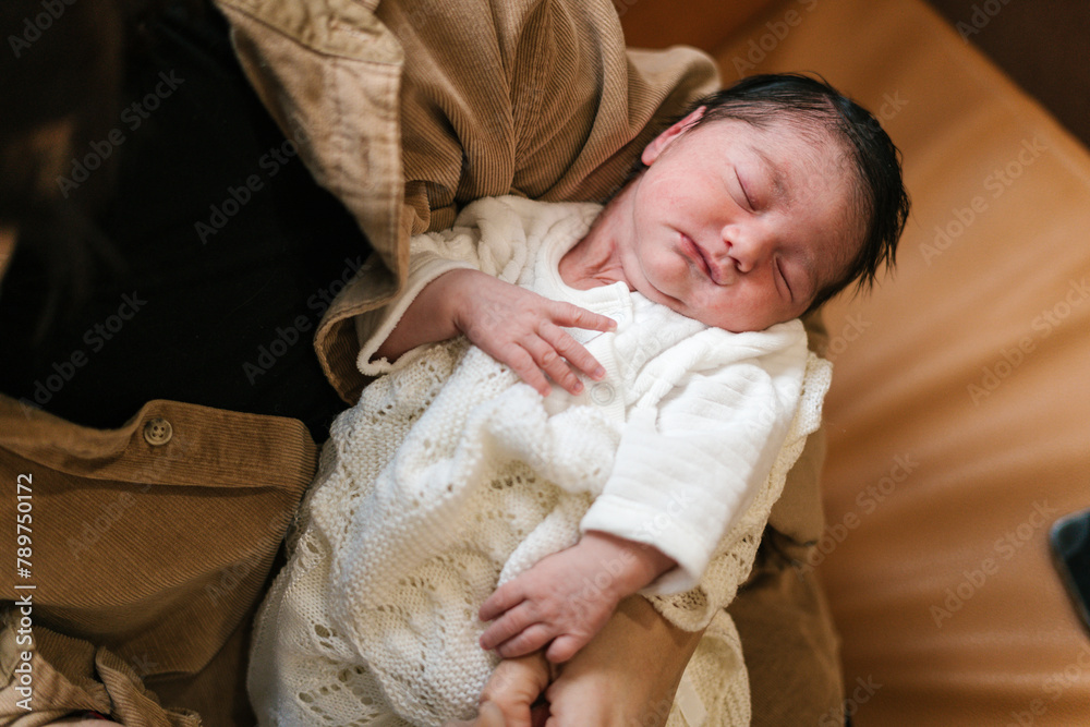 Cute sleeping baby in arms of unrecognizable mother Cute sleeping baby in arms of unrecognizable mother