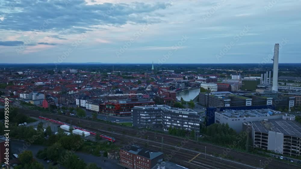 An aerial drone view of Stadthafen, or the city port of Münster, Germany. This modern urban port area features a waterfront path and a row of bars and restaurants, many with terraces. An aerial drone view of Stadthafen, or the city port of Münster, Germany. This modern urban port area features a waterfront path and a row of bars and restaurants, many with terraces.