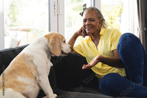 African American senior woman sitting at home, talking to her dog photo