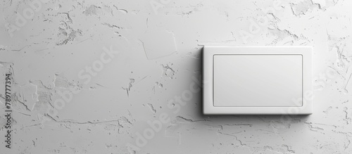 A plain wall with a white light switch placed on it, ready to control the room's lighting