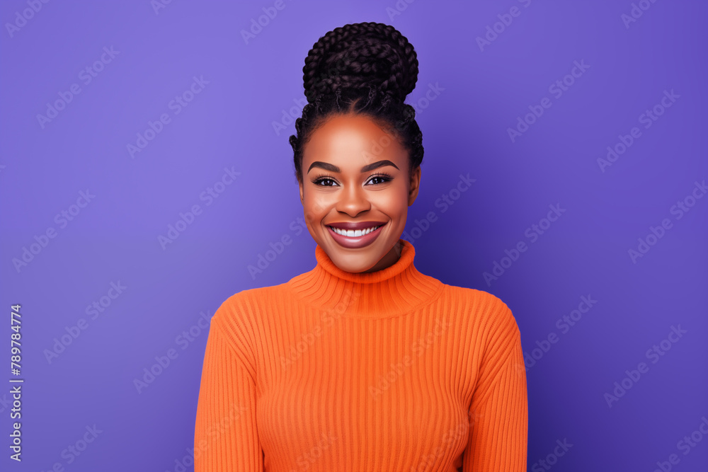 Fototapeta premium A woman's radiant smile captures the essence of joy, complemented by her stylish orange turtleneck and chic bun, against a lively purple background.