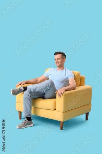 Handsome man sitting in yel...